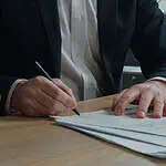 two men signing paperwork