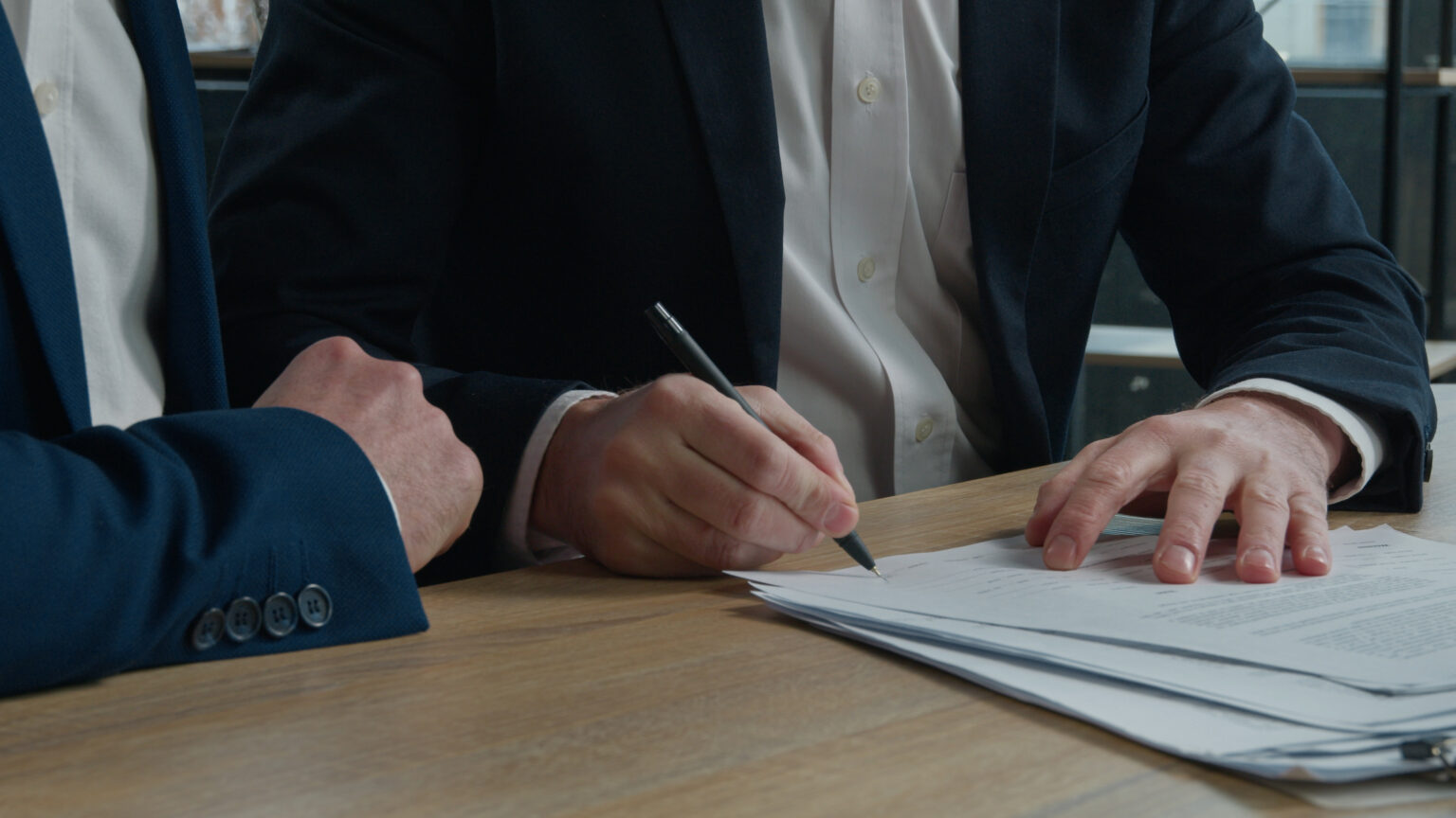 two men signing paperwork